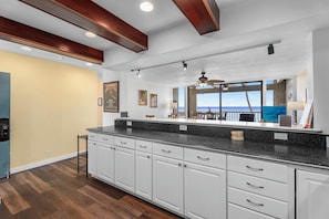 Enjoy ocean views from the kitchen window, where a large island and white cabinetry with silver handles await.