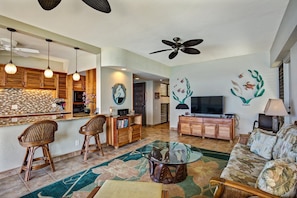 A spacious living area with a kitchen, a dining area, and a seating area with a sofa and chairs.