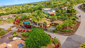 Un quartier résidentiel avec des maisons, une piscine et une végétation luxuriante.