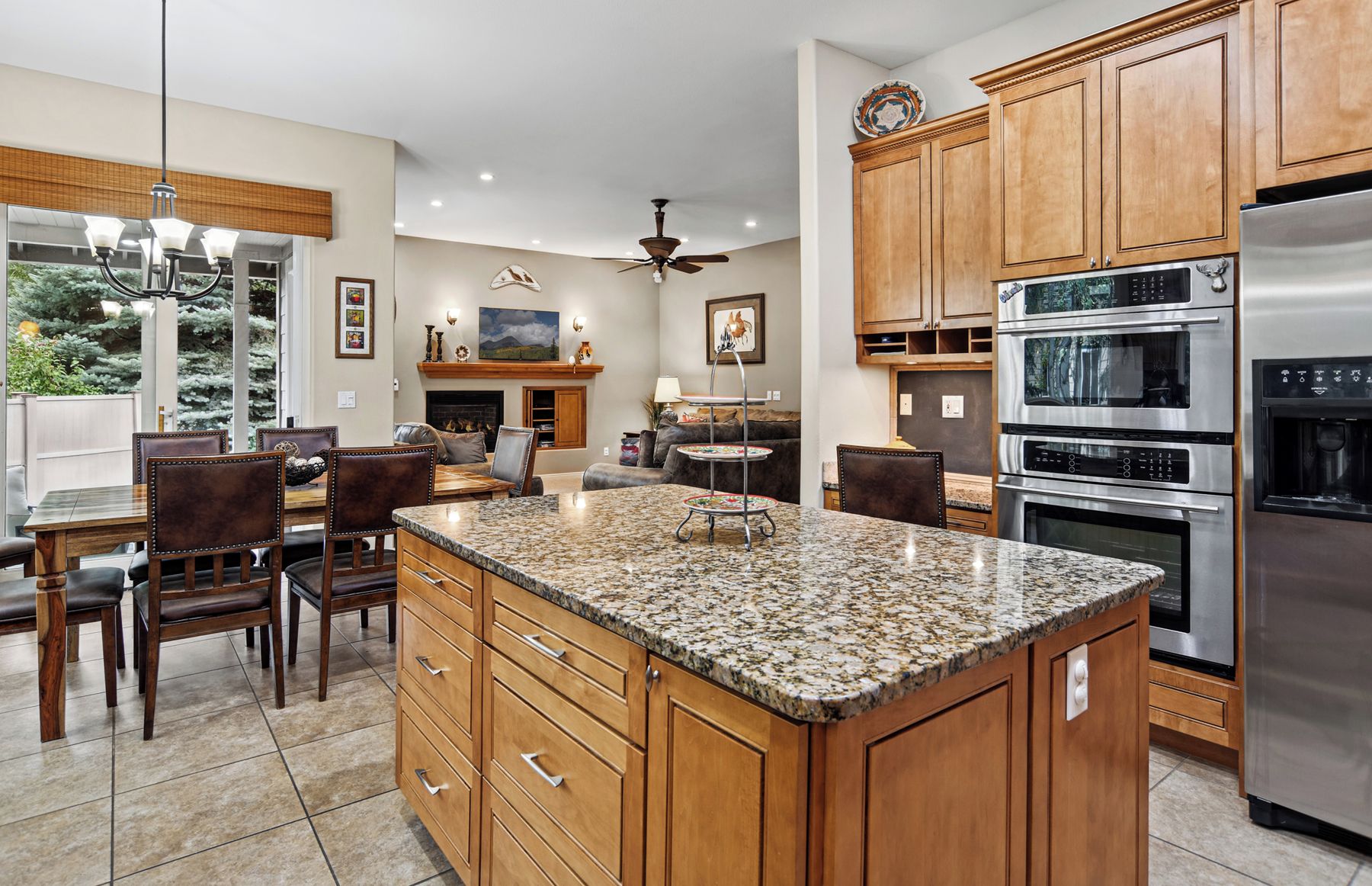 A modern kitchen with granite countertops, stainless steel appliances, and wooden cabinetry.