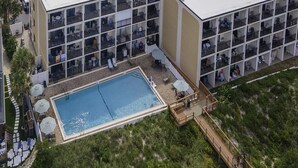 A hotel with a rooftop pool, outdoor seating, and a multi-story building with balconies. - Million Dollar Views ~ Heated Pool ~ King Bed (St Augustine)