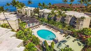 Un resort con piscina, palmeras y vista al océano.