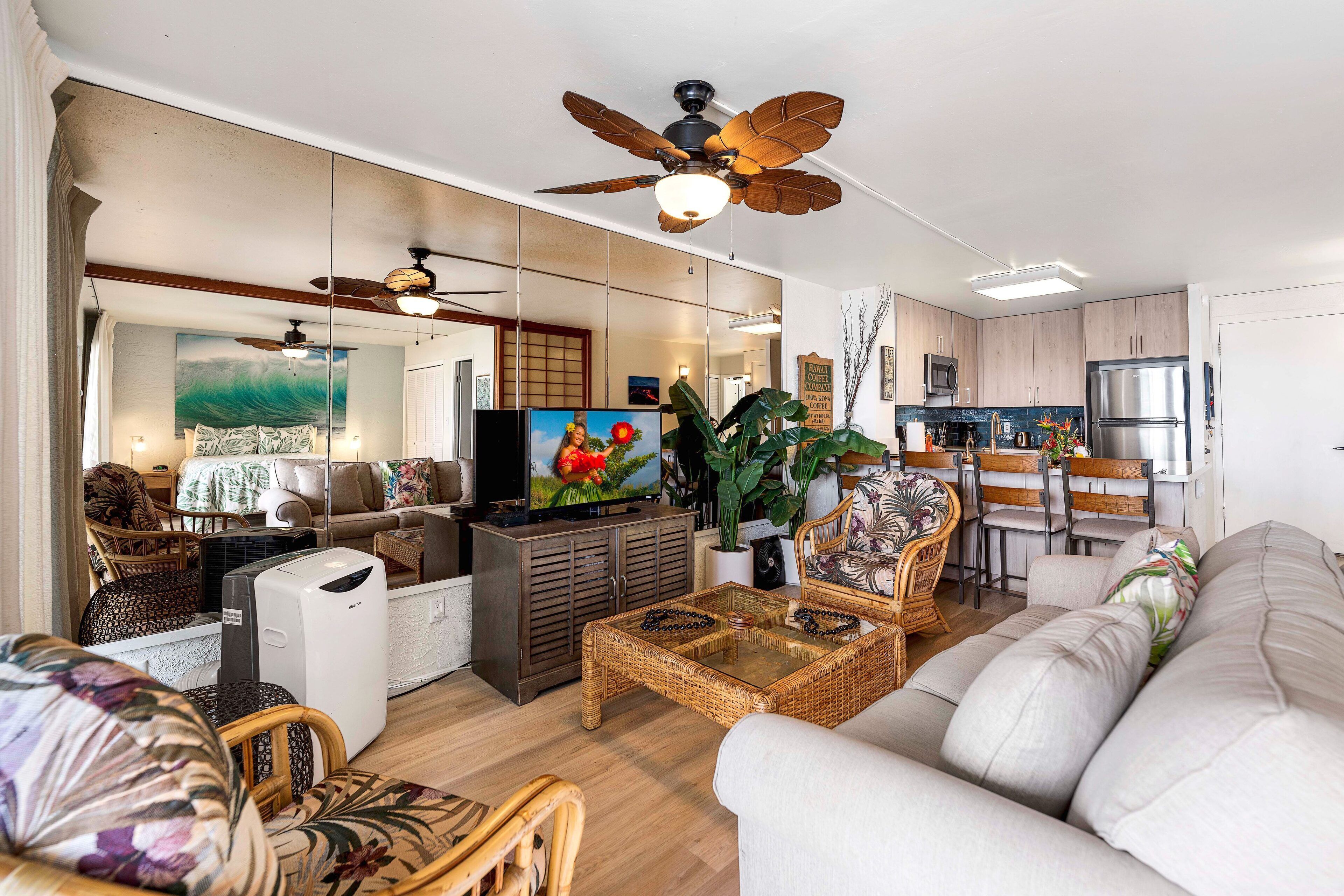 A modern living room with a sofa, chairs, a coffee table, and a television.