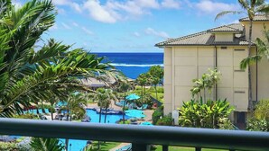 Ein Resort mit Poolanlage, Palmen und Blick auf den Ozean.