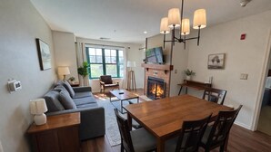 Ein modernes Wohnzimmer mit einer Couch, einem Esstisch und einem Kamin.