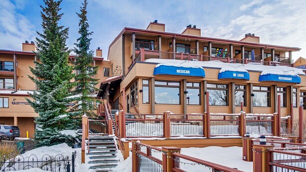 Un hôtel avec un restaurant mexicain au rez-de-chaussée, un escalier menant aux étages supérieurs et un paysage enneigé.