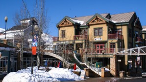A historic building with a stone facade, multiple balconies, and a staircase leading to the entrance.