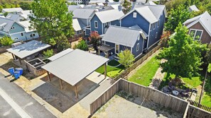A residential area with multiple houses, a covered patio, and a fenced yard.
