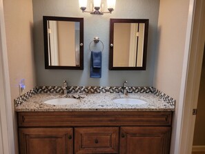 A bathroom with two sinks, a mirror, and a towel rack. - Modern ranch house in East Tucson is set up for a perfect temporary stay (Tucson)