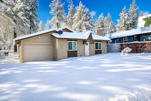A two-story house with a garage, a covered porch, and a fenced yard.