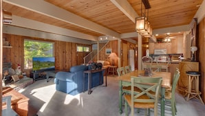 A cozy cabin interior with a living area, dining space, and kitchen. - Cozy Wood Cabin By Tahoe Getaways - 3 BR w Hot Tub, Fireplace + Backs to Forest (Carnelian Bay)