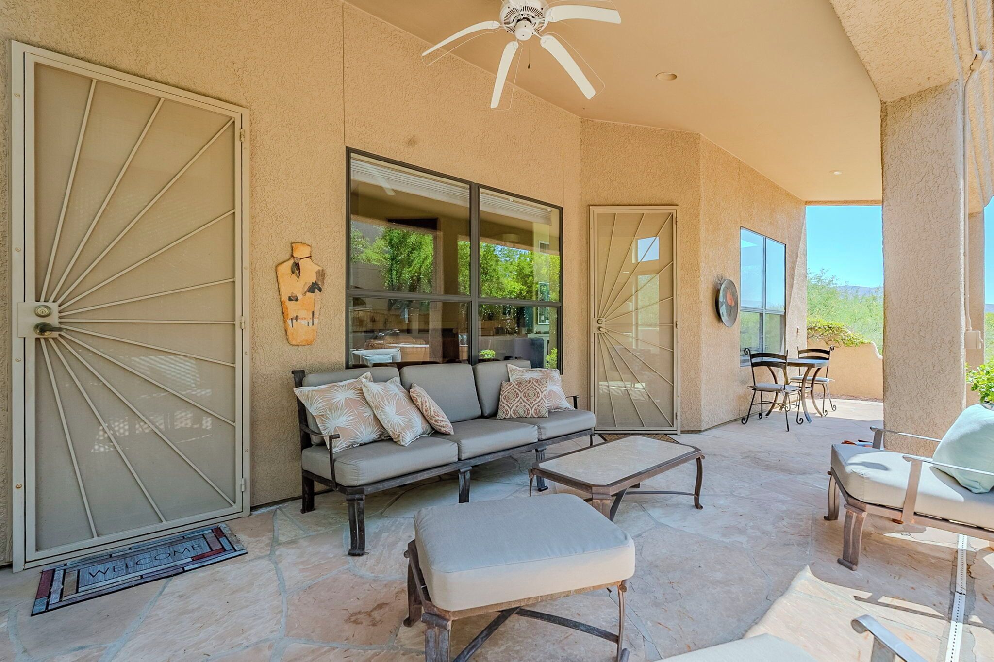 A spacious patio with a sofa, ottoman, and dining set.
