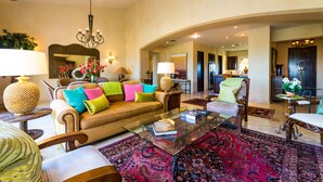 A spacious living room with a sofa, armchairs, a coffee table, and a large rug. - Resort Living in Ocean View Penthouse at Esperanza (Cabo San Lucas)