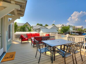 A wooden deck with outdoor furniture, a table, and a covered area. - Carlton Landing! Cozy Garage Apartment close to all amenities! (Carlton Landing)
