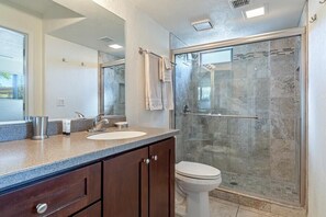 A bathroom with a glass shower enclosure, a sink, and a toilet. - Highly desired Eastside 1st floor - expanded patio and great Mountain Views! (Tucson)
