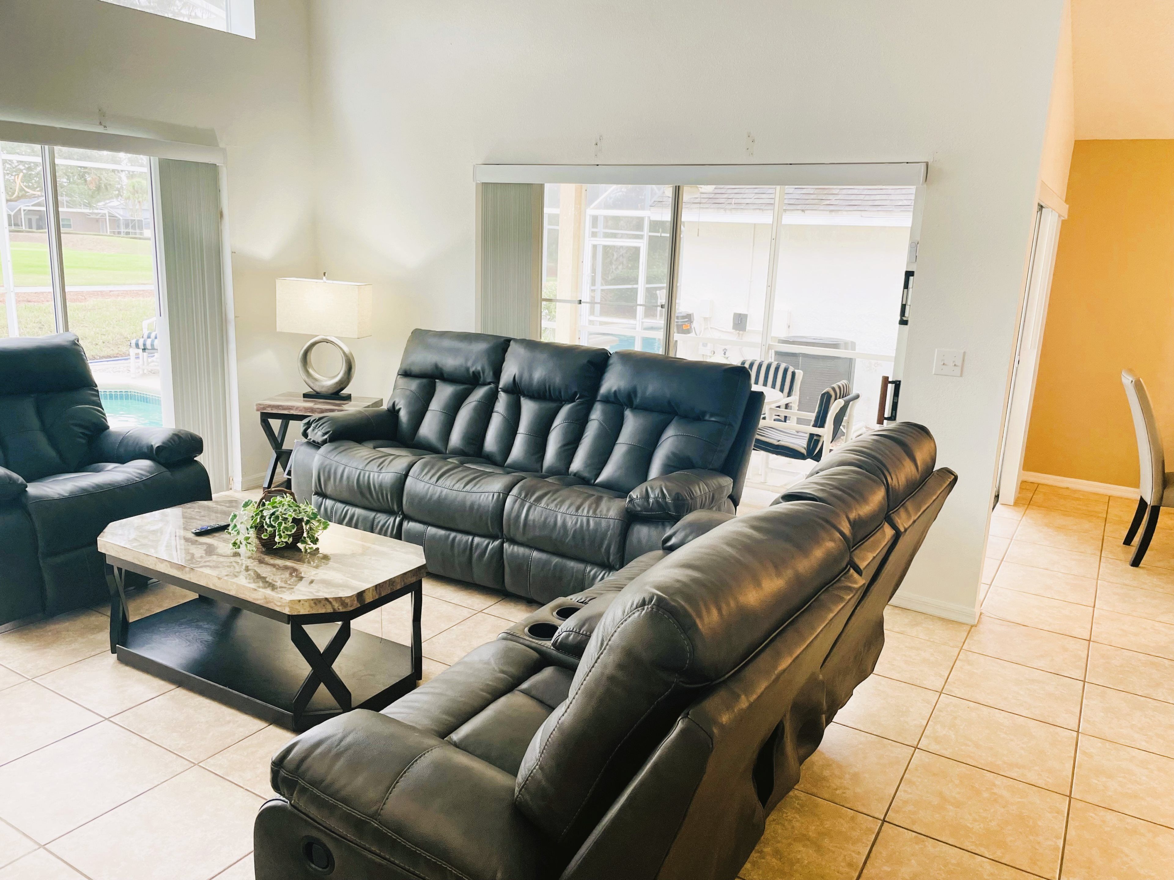 A living room with a black leather sofa, a matching armchair, and a coffee table.