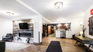 A modern living room with a fireplace, a mounted TV, and a dining area with a wooden table and chairs.