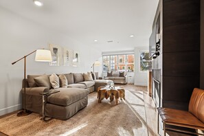 Relax in this cozy living space with a comfortable sofa, coffee table, and floor lamp, plus a fireplace for warmth.