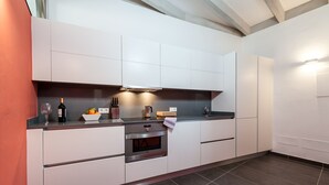 A modern kitchen with white cabinets, a built-in oven, and a dark countertop. - CAN CABRIT - Modern villa with private pool at the foot of the mountain. Free WiFi (Alaro)