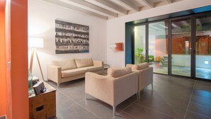 A modern living room with a beige sofa, a coffee table, and a large abstract painting on the wall. - CAN CABRIT - Modern villa with private pool at the foot of the mountain. Free WiFi (Alaro)