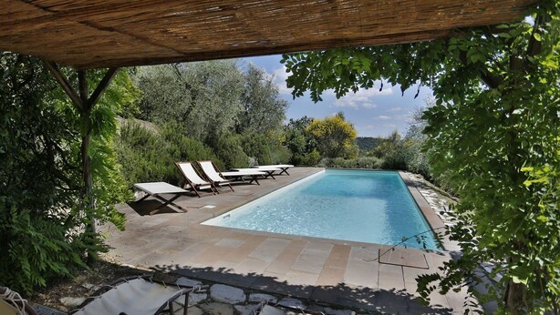 A rectangular swimming pool with lounge chairs and a table under a wooden pergola, surrounded by greenery. - Wonderful private villa with WIFI, private pool, TV, terrace and panoramic view, close to Florence (Torre A Cona)