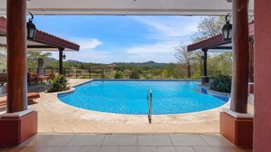 Una piscina con vista despejada al paisaje circundante, incluyendo colinas y árboles.