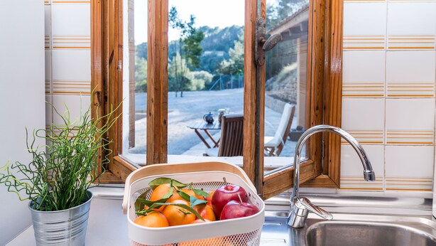 A kitchen with a sink, a window with wooden frames, a potted plant, and a fruit basket. - CAN CAPET - Villa with private pool in Andratx. Free WiFi (Andratx)
