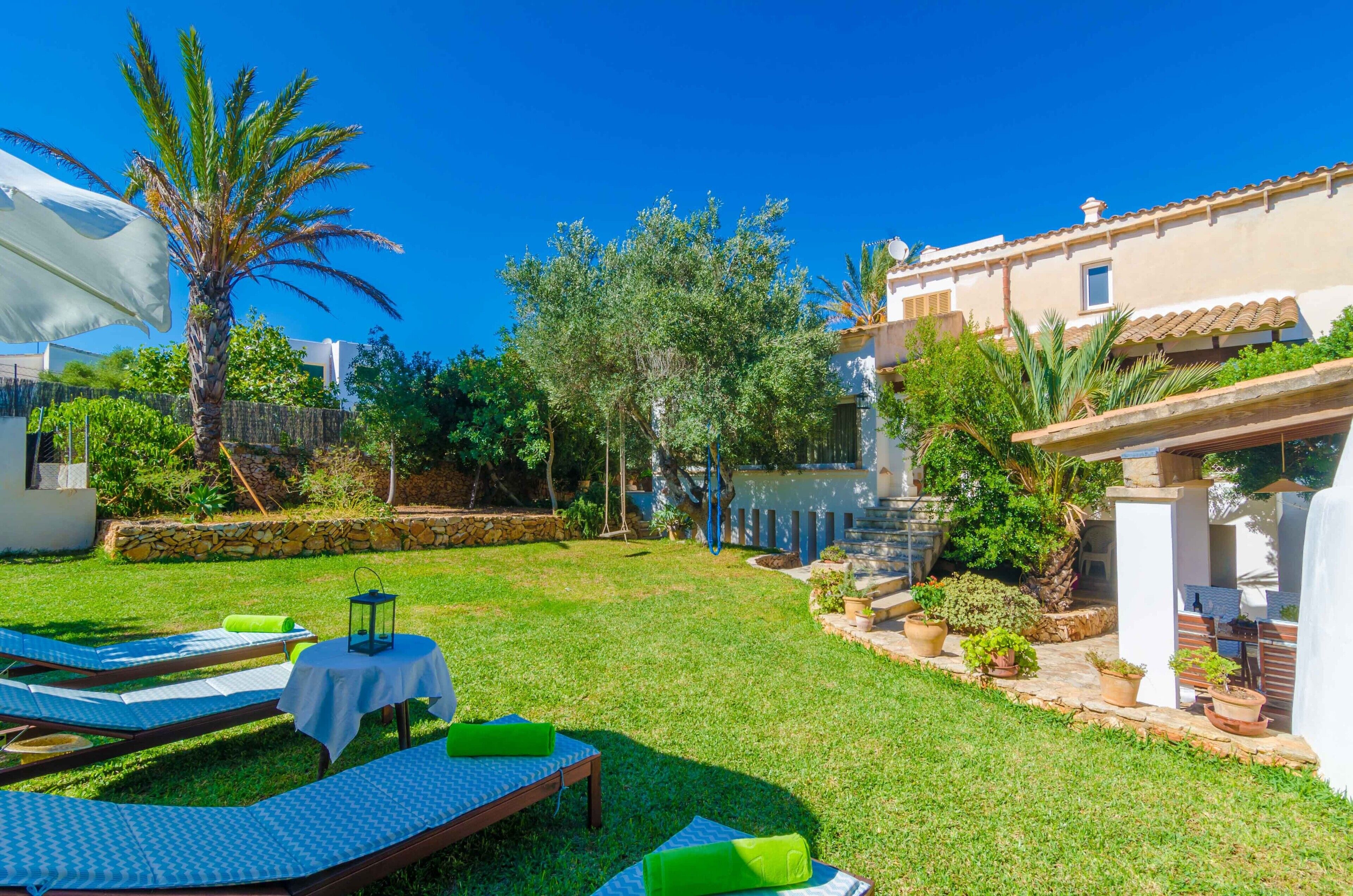 A well-maintained outdoor area with lounge chairs, a small table, and potted plants.