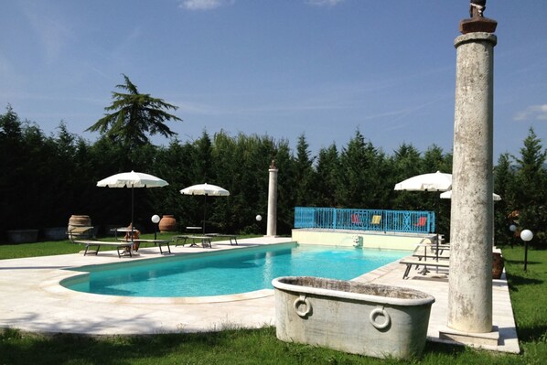 Relax by the pool surrounded by a deck and lush greenery.