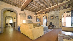 A spacious living area with a stone fireplace, a sofa, and a television.