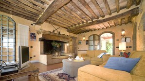 A cozy living room with a fireplace, a sofa, a coffee table, and a television.