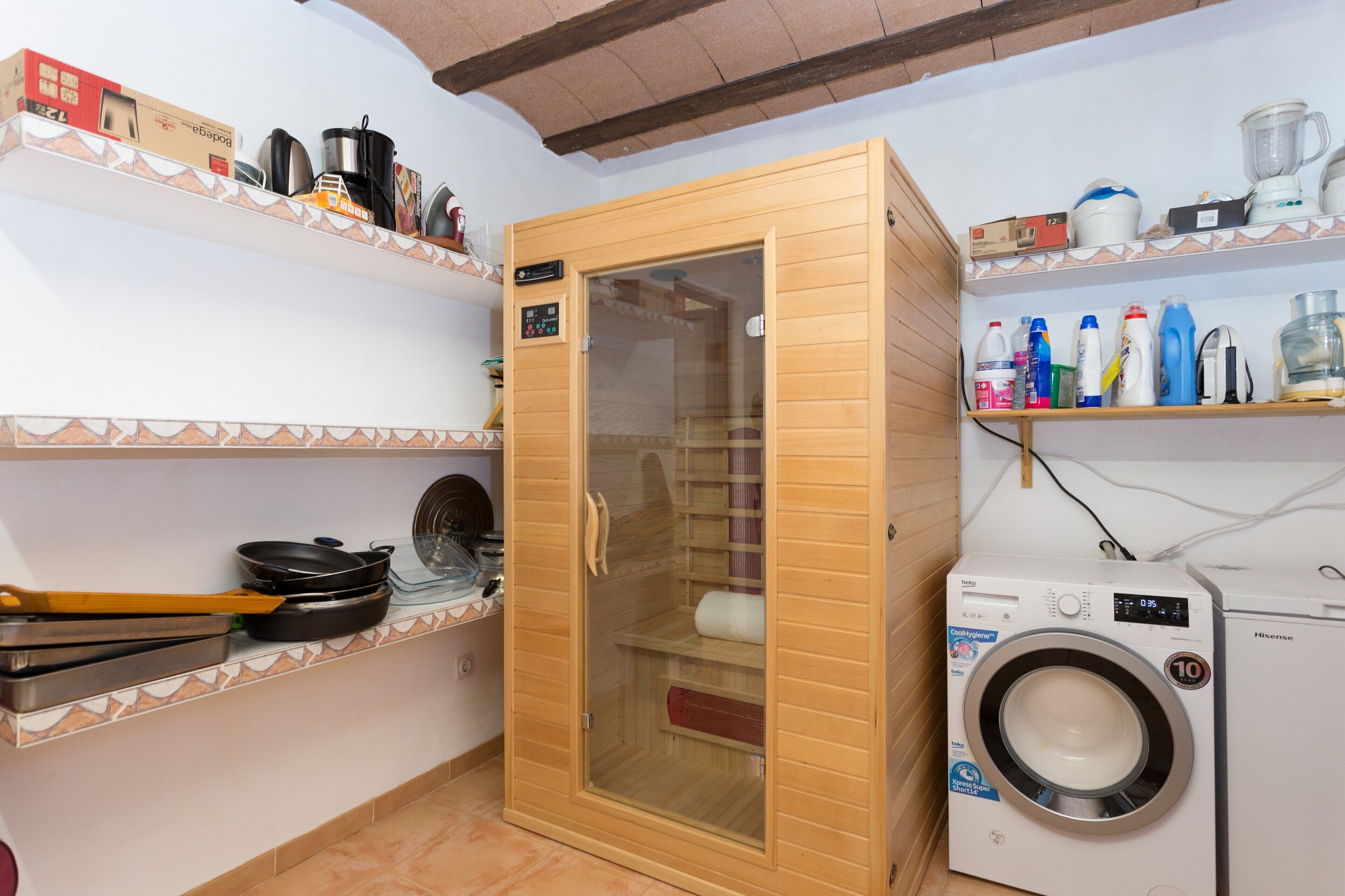 Uma cozinha compacta com armário de madeira, micro-ondas e máquina de lavar.
