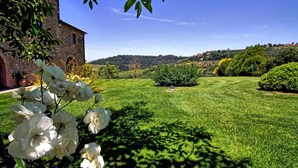 A lush green lawn with a stone building and a clear blue sky. - Wonderful private villa with A/C, private pool, WIFI, hot tub, TV, patio, close to San Gimignano (Petrognano)