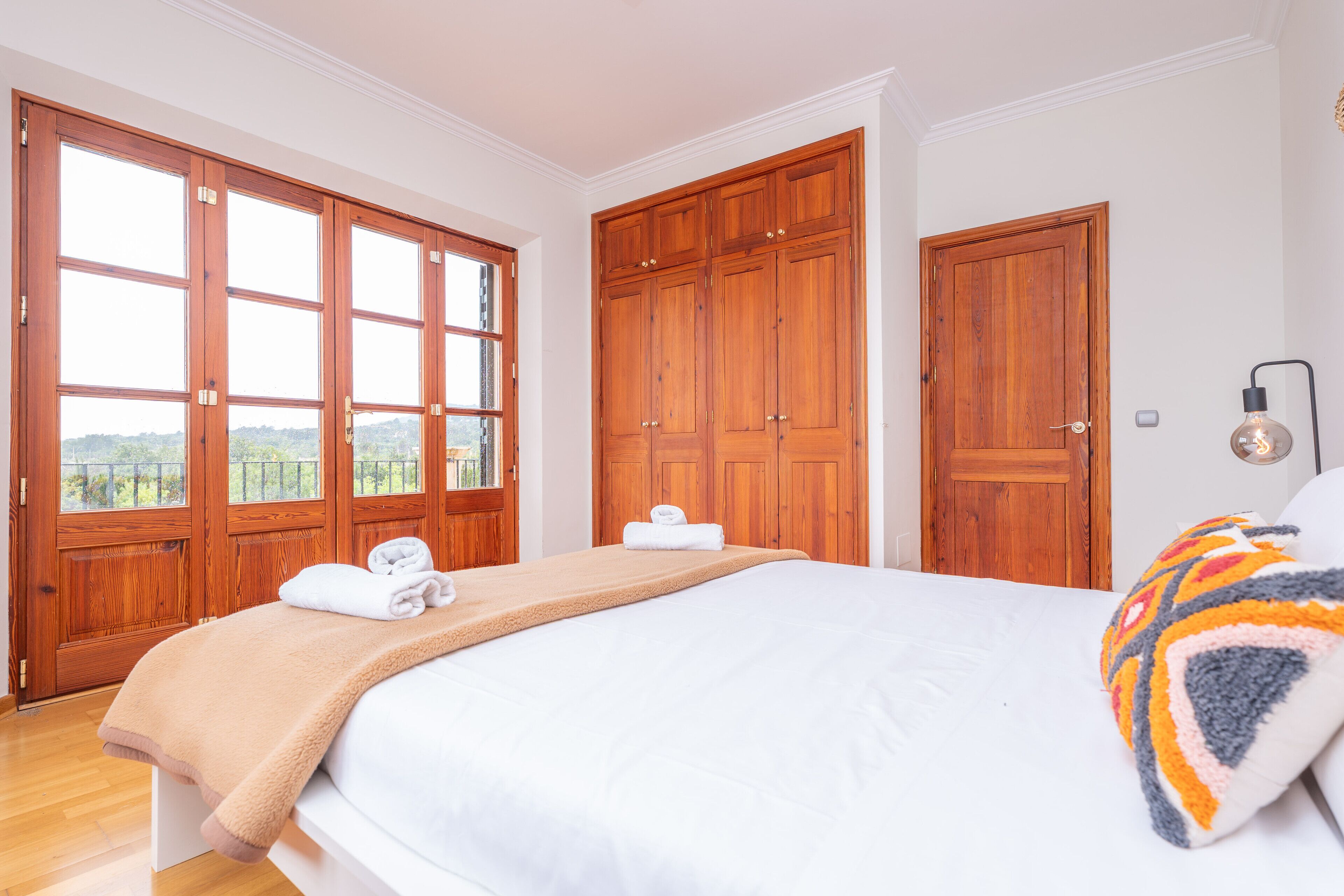 Ein Schlafzimmer mit einem großen Bett, einem Holzschrank und einem Fenster mit Blick.