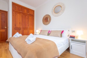A neatly made bed with a brown blanket and rolled towels, wooden wardrobe, two wall mirrors, and bedside lamps. - CAN BIELET - Villa with private swimming pool in BINISSALEM with free WiFi (Binissalem)