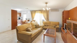 A living room with two sofas, a coffee table, and a TV stand. - CASCADES - Apartment with shared pool in Dénia. (Denia)