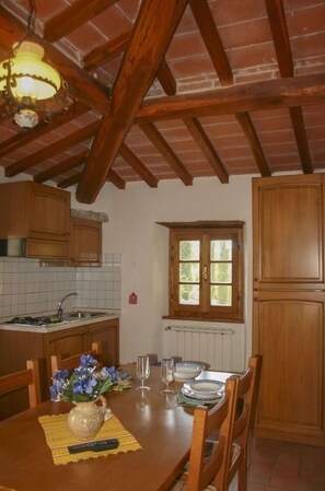 A kitchen with wooden cabinets, a window, and a table with chairs.