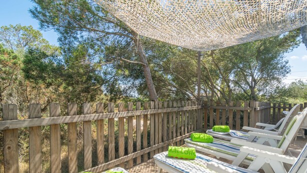 An outdoor seating area with wooden fences and lounge chairs. - ES JAÇ - Villa with terrace in Cala s'Almonia with free Wi-Fi (Cala Llombards)