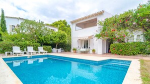 A rectangular swimming pool with white lounge chairs and a covered patio area. - CAN FERRO - Villa with private pool in Cala Blava. Free WiFi (Llucmajor)