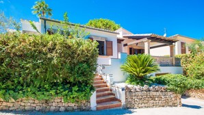 A two-story house with a stone wall, a staircase, and a covered porch. - CAN CAIMARI - Chalet for 6 people in Bonaire. (Mal Pas-Bon Aire)