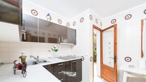 A kitchen with a stainless steel range hood, a sink, and a wooden door. - CAN CAIMARI - Chalet for 6 people in Bonaire. (Mal Pas-Bon Aire)