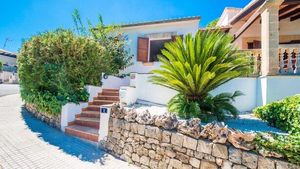 A stone wall with steps leading to a white building with a window and a door. - CAN CAIMARI - Chalet for 6 people in Bonaire. (Mal Pas-Bon Aire)
