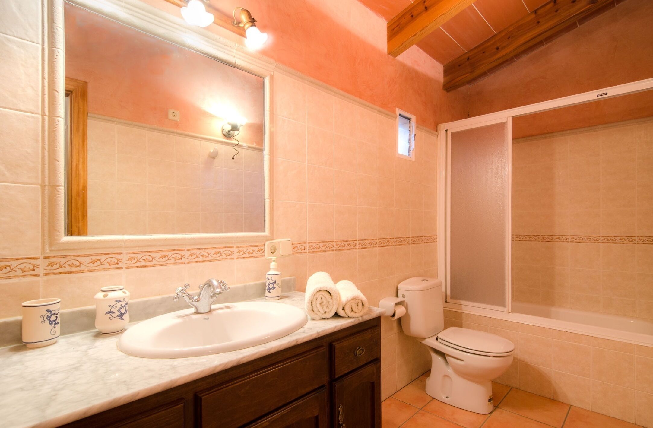 Une salle de bain équipée d’un lavabo, d’un miroir, de toilettes et d’une douche.