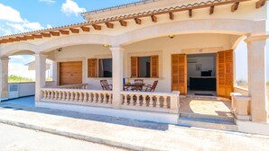 Un bâtiment à deux étages doté d’un patio couvert, de volets en bois et d’une enseigne portant le numéro 47.