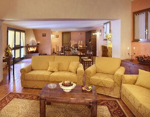 Cozy living room with a fireplace, traditional decor, and a dining area.