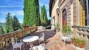 A terrace with outdoor furniture, a stone balustrade, and potted plants. - La Grotta - Apartment with swimming pool (Montespertoli)