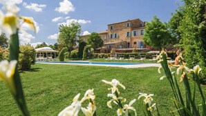 A pool area with a gazebo, a brick building with multiple windows, and lush greenery. - Villa Giare - Villa with private pool (Fratticciola)