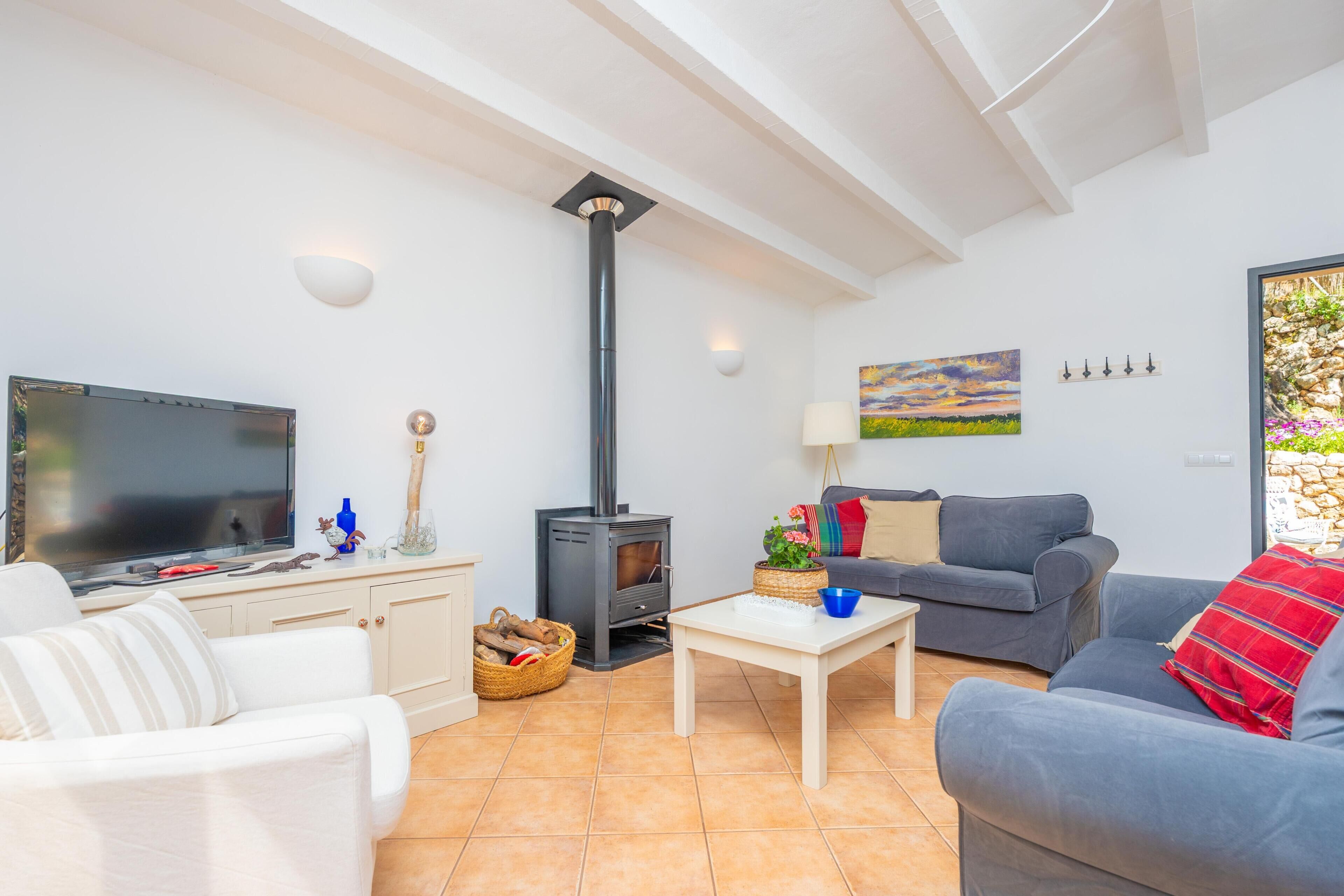 A living room with a TV, sofa, table, and a fireplace.
