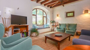 A living room with a television, seating, and a ceiling fan. - CAS PILOT - Villa with private pool in Santa Maria del Cami. Free WiFi (Santa Maria)