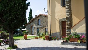 A stone building with a tiled roof, potted plants, and a cobblestone pathway. - Nice apartment for 6 people with pool, WIFI and TV (Canova)